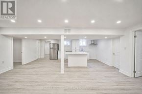 Burlington (Shoreacres) apartment for rent - A spacious, empty room with a white kitchen island in the middle.