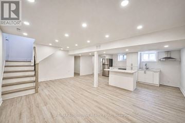 Burlington (Shoreacres) apartment for rent - A spacious room with a staircase and a kitchenette.