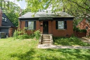 Toronto (O'connor-Parkview) apartment for rent - A red brick house with a black door and a green lawn in front.