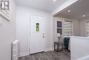 Toronto (O'connor-Parkview) apartment for rent - A white door with a glass window is in the middle of a room with a radiator on the left and a lamp on the right.