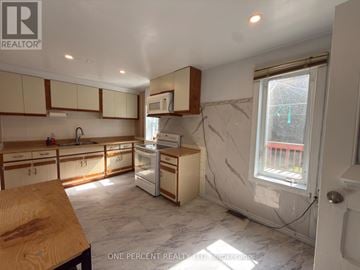 Niagara Falls (Downtown) apartment for rent - A kitchen with white cabinets and a marble floor.