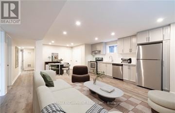 Hamilton (Gilbert) duplex for rent - A modern kitchen with stainless steel appliances and a dining area with a table and chairs.