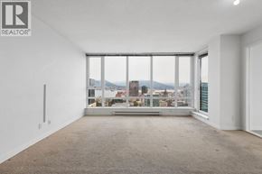 Vancouver apartment for rent - A large, empty room with a view of the cityscape outside the window.