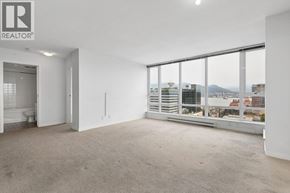 Vancouver apartment for rent - A large, empty room with a view of the cityscape outside the window.