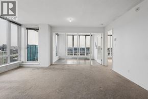 Vancouver apartment for rent - A large, empty room with a view of the city through the windows.