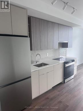 Burlington (Brant) condo for rent - A modern kitchen with a refrigerator, sink, and oven.