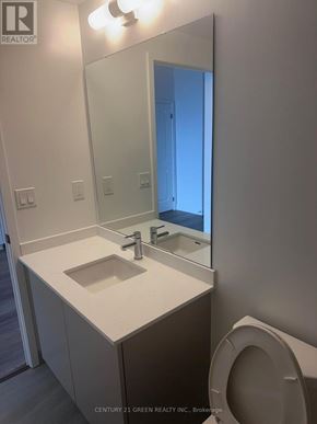 Burlington (Brant) condo for rent - A bathroom with a sink, toilet and mirror.