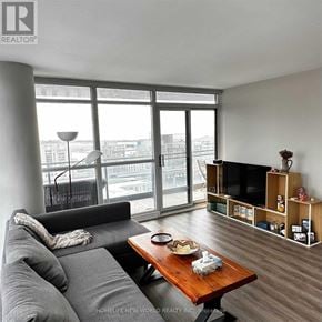 Toronto (Waterfront Communities) condo for rent - A living room with a grey couch and a wooden coffee table.