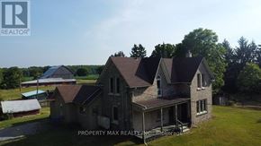 Whitchurch-Stouffville apartment for rent - A large, two-story house with a porch is surrounded by greenery and a clear sky.