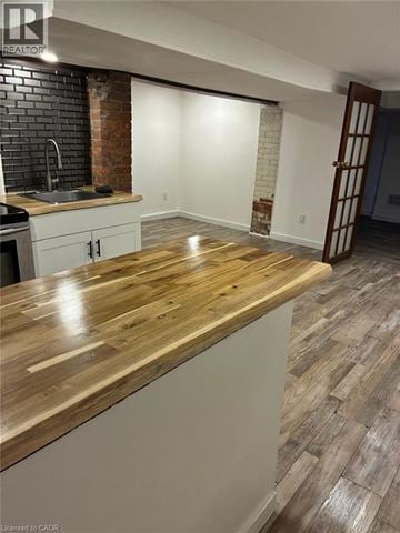 Hamilton apartment for rent - A kitchen with a wooden counter top and a brick wall.