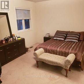 Brampton (Bram East) townhouse for rent - A bedroom with a bed, dresser, and mirror.