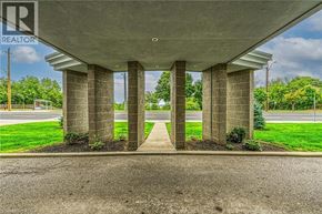 Hamilton condo for rent - A realtor sign is on a pillar of a concrete structure.
