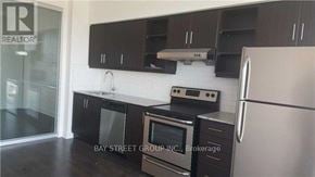 Toronto (Thorncliffe Park) condo for rent - A kitchen with black cabinets and stainless steel appliances.