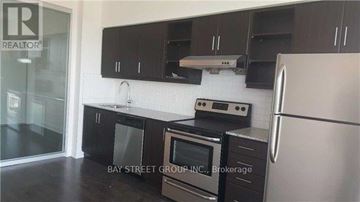Toronto (Thorncliffe Park) condo for rent - A kitchen with black cabinets and stainless steel appliances.
