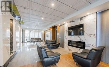 Toronto (Bendale) condo for rent - A living room with a black leather couch and a television on the wall.