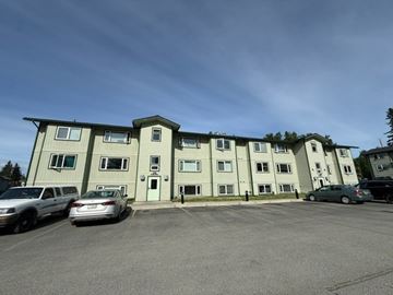 Anchorage apartment for rent - A parking lot in front of a two-story apartment building.