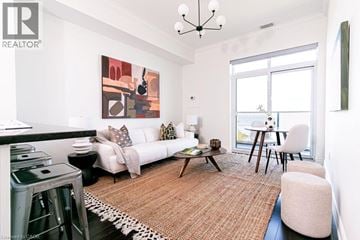 Stoney Creek condo for rent - A living room with a white couch, a coffee table, and a painting on the wall.