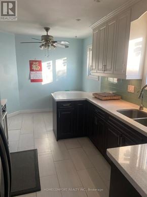 Toronto (Agincourt North) apartment for rent - A kitchen with a fan on the ceiling and a fridge on the left.