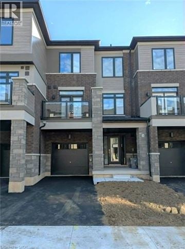 Brantford townhouse for rent - A large, modern house with a garage and a driveway.