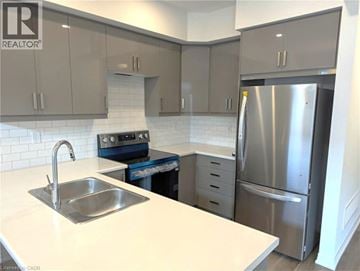 Brantford townhouse for rent - A modern kitchen with a stainless steel refrigerator and a white countertop.