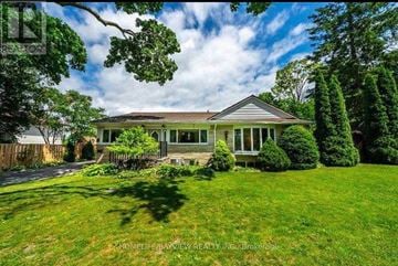 Whitchurch-Stouffville apartment for rent - A house with a well-maintained lawn and trees in the background.