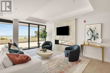 Fort Erie (Crystal Beach) condo for rent - A living room with a large window, a sofa, a chair, a coffee table, and a painting on the wall.