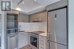 Toronto (Church-Yonge Corridor) condo for rent - A modern kitchen with stainless steel appliances and white cabinetry.