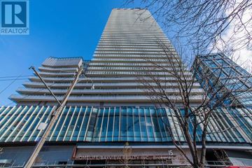 Toronto (Waterfront Communities) condo for rent - A tall building with a sign that reads "HOMELEE BAYVIEW ESTATE".