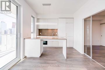 Toronto (Waterfront Communities) condo for rent - A modern kitchen with white cabinets and a large island.