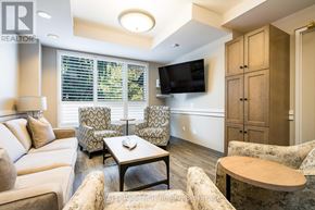 Collingwood condo for rent - A living room with a couch, chairs, and a television.