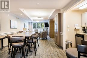 Collingwood condo for rent - A modern kitchen with dark wood floors and a dining area with a table and chairs.