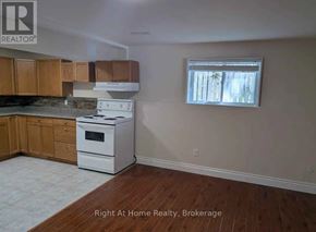 Clarington (Bowmanville) apartment for rent - A kitchen with wooden cabinets and a white stove top oven.