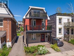 Ottawa apartment for rent - A two-story house with a red door and balcony is surrounded by other houses.