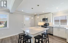 Burlington (Mountainside) apartment for rent - A kitchen with a white island and black stools.