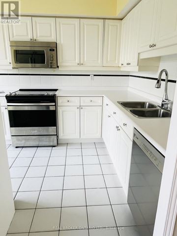 Toronto (Mimico) condo for rent - A white kitchen with a black oven and a white tiled floor.