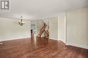 Ottawa apartment for rent - A spacious room with wooden floors and a staircase.