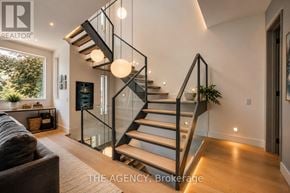Toronto (North Riverdale) apartment for rent - A modern staircase with glass railings and wooden steps.
