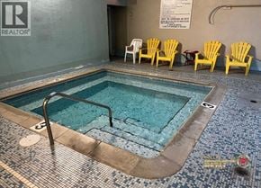 Burnaby apartment for rent - A pool with a metal ladder and yellow chairs.