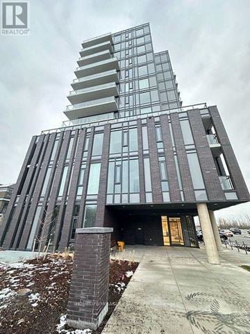 Brampton (Northwest Brampton) condo for rent - A modern building with a glass facade and a tall tower on top.