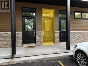 Russell condo for rent - A building with a yellow door and a sign that says REALTOR.