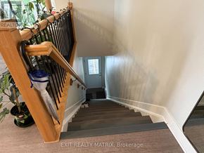 Russell condo for rent - A staircase with a wooden handrail and a potted plant on the left.