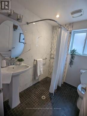 Toronto (Greenwood-Coxwell) triplex for rent - A bathroom with a white sink and a white toilet.