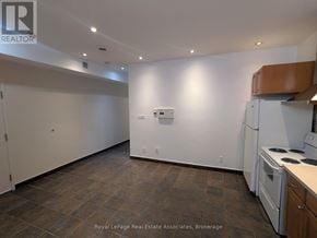 Mississauga (Port Credit) multi-family for rent - A kitchen area with a tile floor and a white refrigerator.