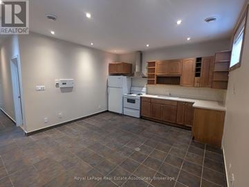 Mississauga (Port Credit) multi-family for rent - A kitchen with brown cabinets and a white fridge.