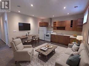 Mississauga (Port Credit) multi-family for rent - A living room with a couch, chairs, a coffee table, and a television.