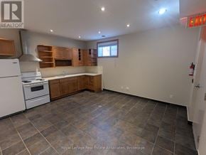 Mississauga (Port Credit) multi-family for rent - A kitchen with a white stove and wooden cabinets.