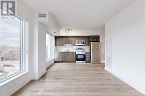 Toronto (Yorkdale-Glen Park) condo for rent - A spacious kitchen with wooden floors and white walls.