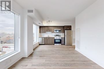 Toronto (Yorkdale-Glen Park) condo for rent - A spacious kitchen with wooden floors and white walls.