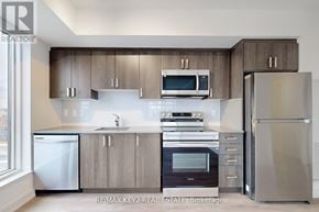 Toronto (Yorkdale-Glen Park) condo for rent - A modern kitchen with stainless steel appliances and wooden cabinets.