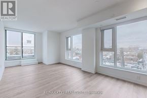 Toronto (Yorkdale-Glen Park) condo for rent - A large, empty room with wooden floors and windows overlooking a snowy landscape.